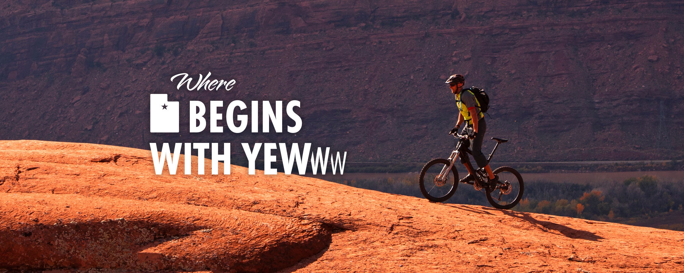 Person on a mountain bike at the top of a red rock formation with "Where Utah Begins with Yewww" text overlay.