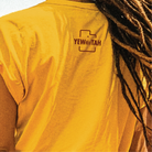 Yellow shirt with 'YEWWATAH' logo worn by a person with dread locks hair.