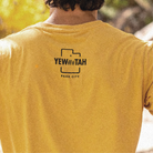 Yellow t-shirt with 'YEWWWTAH PARK CITY' logo on the back, worn by a person.