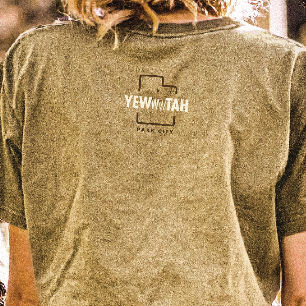 Person wearing a green t-shirt with 'YEWWWTAH - Park City' printed on the back.