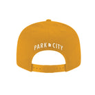 Yellow/gold flat bill cap with embroidered 'PARK CITY, UT' text on a white background
