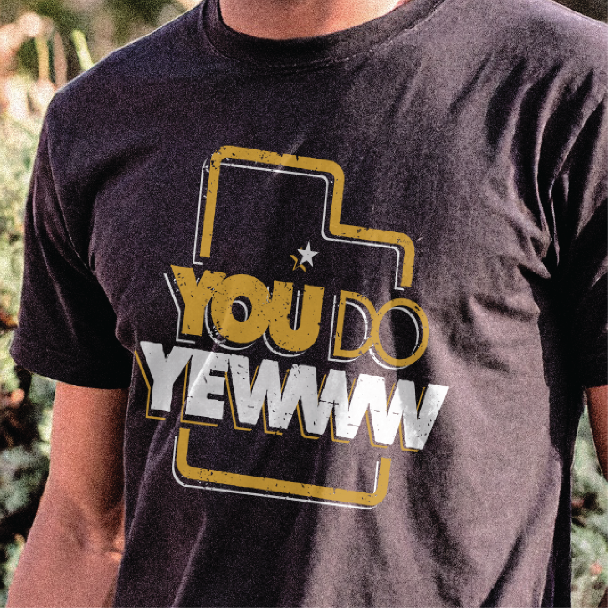 Person wearing a black t-shirt with a graphic design and text that reads 'you do yewww'.