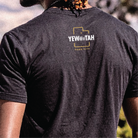 Person wearing a black t-shirt with 'YEWWWTAH Park City' printed on the back.