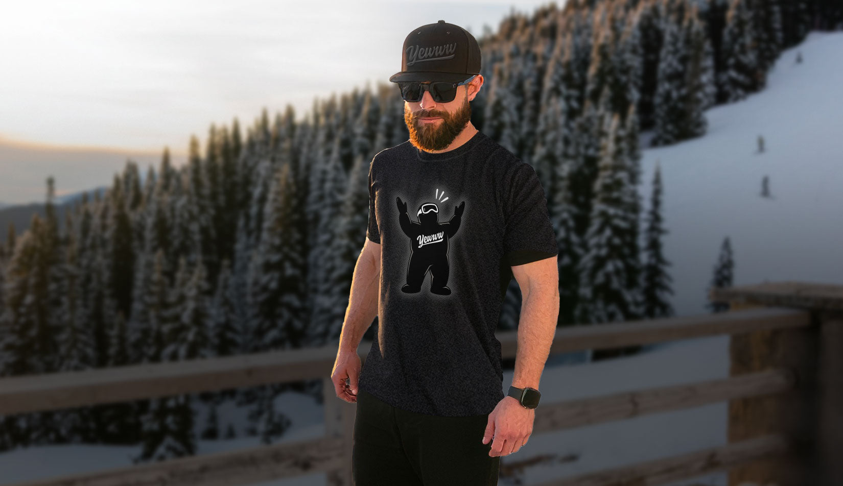 Man wearing a black t-shirt with a graphic design in a snowy mountain landscape